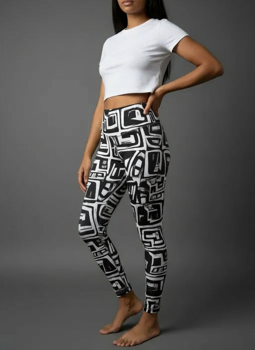 Person wearing a white crop top and black and white geometric patterned leggings on a gray background